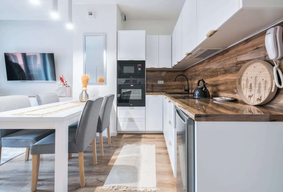 This sleek and modern kitchen is a chef's dream, boasting ample counter space and top-of-the-line appliances. The clean white design creates a bright and inviting culinary haven.