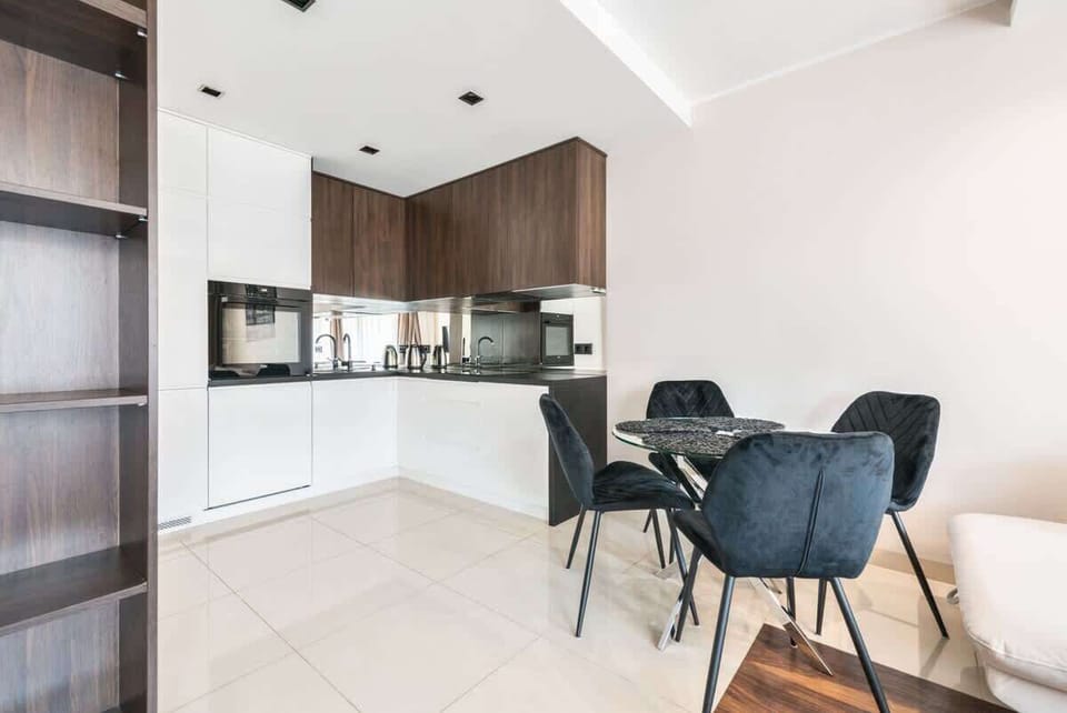 A sleek, modern kitchen with white cabinetry, integrated appliances, and a tiled floor. The space feels bright and functional.

