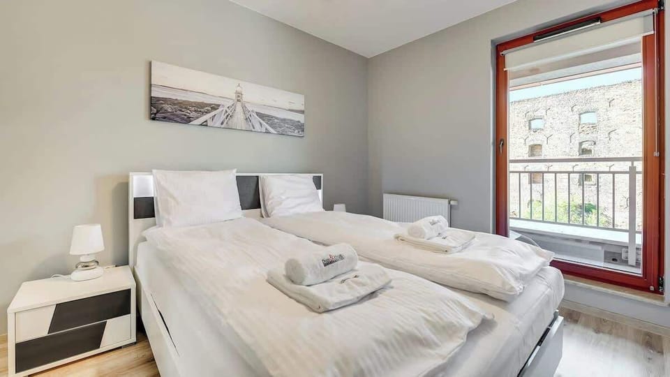 A cozy bedroom with a carefully made bed, white bedding. The decor is modern but friendly.
