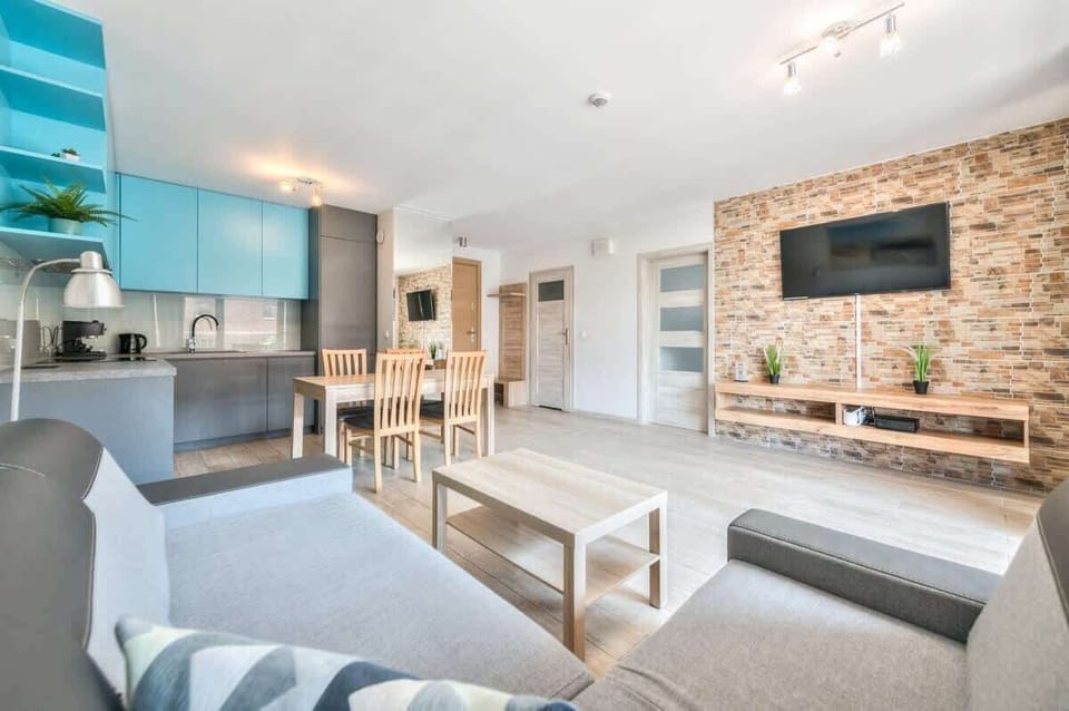 Bright, modern living room with a grey sofa and coffee table. The room is well lit and has a contemporary decor.