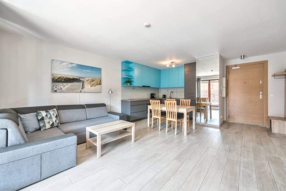 Bright, modern living room with a grey sofa and coffee table. The room is well lit and has a contemporary decor.
