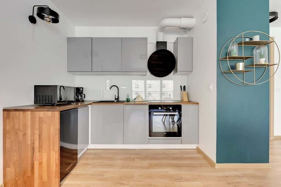 The stylish kitchen, complete with white cabinets, wooden countertops, and fully equipped appliances.
