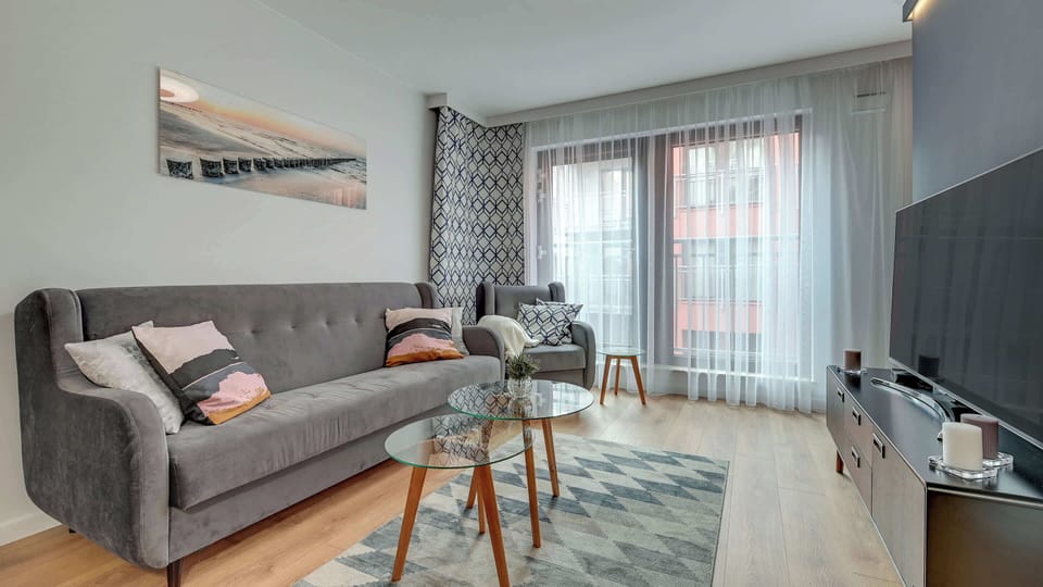 A modern and cozy living area featuring a gray sofa, yellow accents, and tasteful wall art.