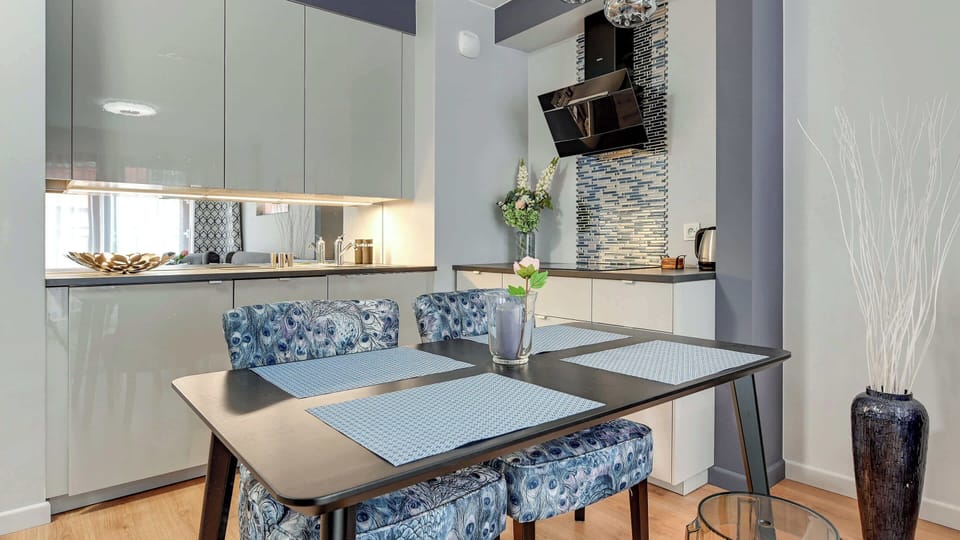 A compact and modern kitchen area with white cabinetry and integrated appliances.