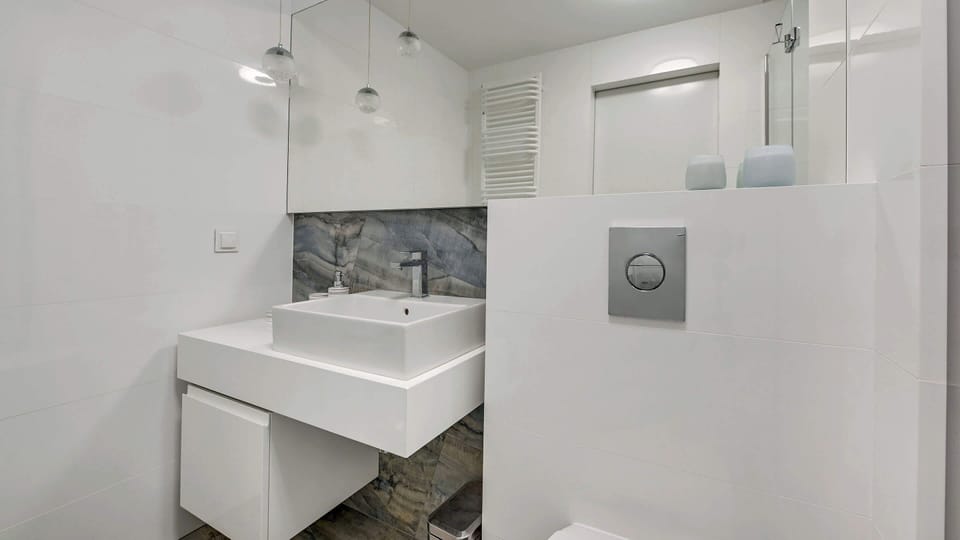 A clean and elegant bathroom with light-colored tiles and a stylish vanity area.
