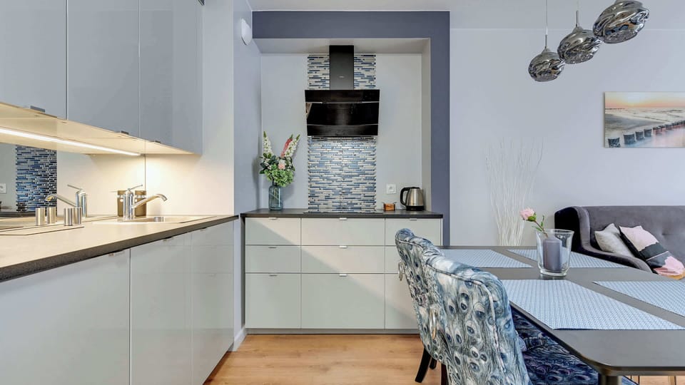A compact and modern kitchen area with white cabinetry and integrated appliances.
