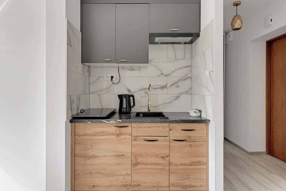 Modern kitchen with full equipment, allowing convenient preparation of meals, bright furniture and functional layout provide comfort.