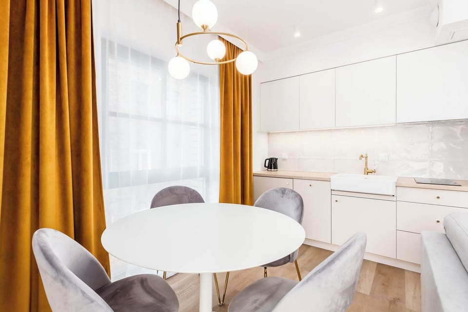 A cozy dining space with a round table and chairs near large windows. Perfect for enjoying meals in daylight.