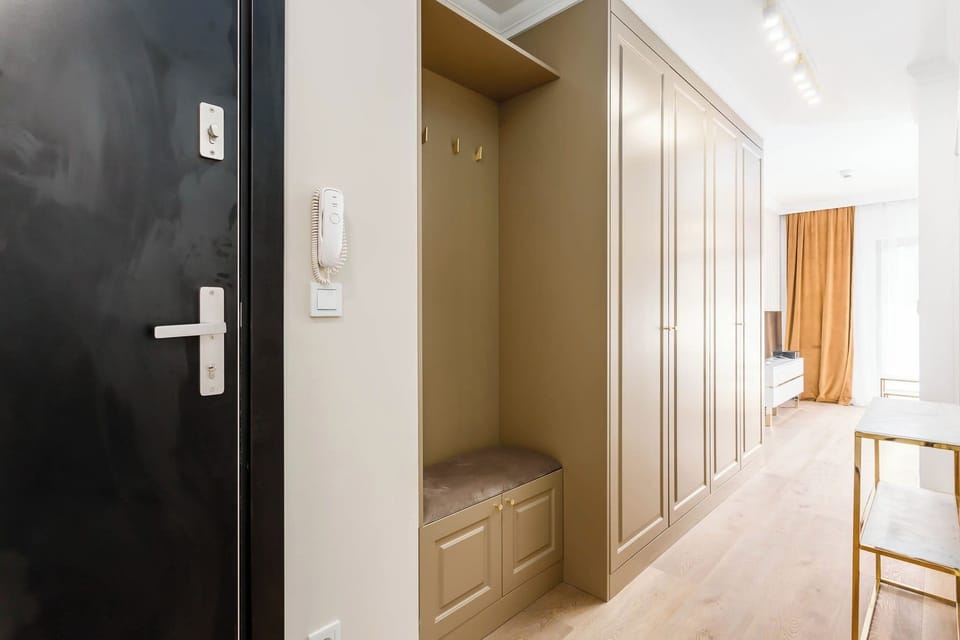 A bright hallway with built-in wardrobe space and wooden flooring. The neutral tones make it look clean and modern.