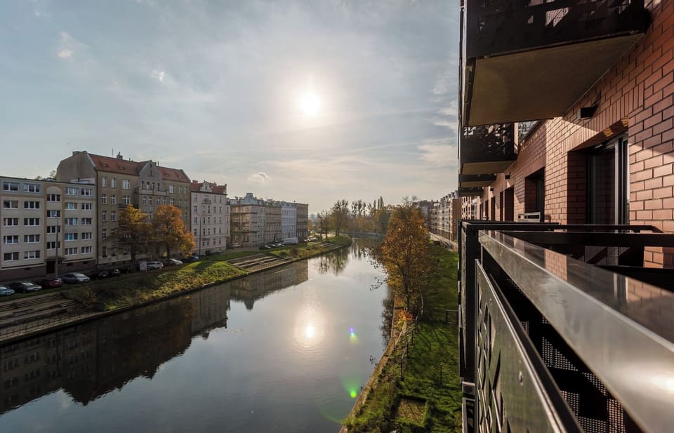 Another balcony shot with the river and buildings under the setting sun. The peaceful view creates a relaxing vibe.