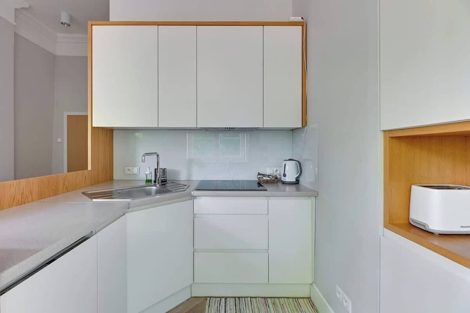 Fully equipped kitchenette, provides the convenience of cooking in a spacious interior. Bright kitchen furniture combined with wooden details create a warm, welcoming atmosphere.