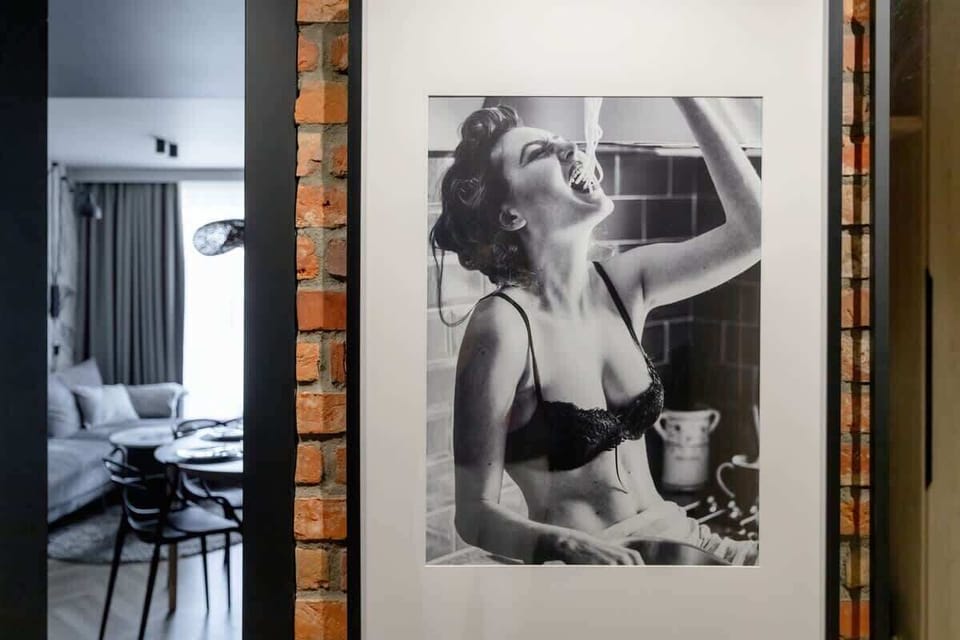A hallway corner with black-and-white artwork of a woman and a glimpse into the living area.

