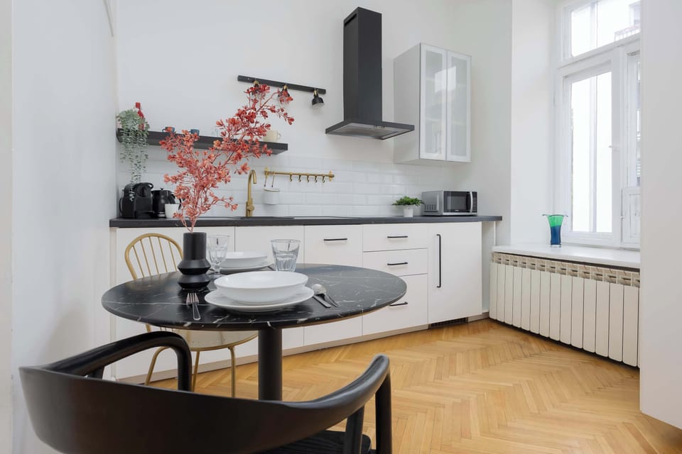 A view of the open-plan space showing the living area with a sofa and a connected dining area with a modern table and chairs.