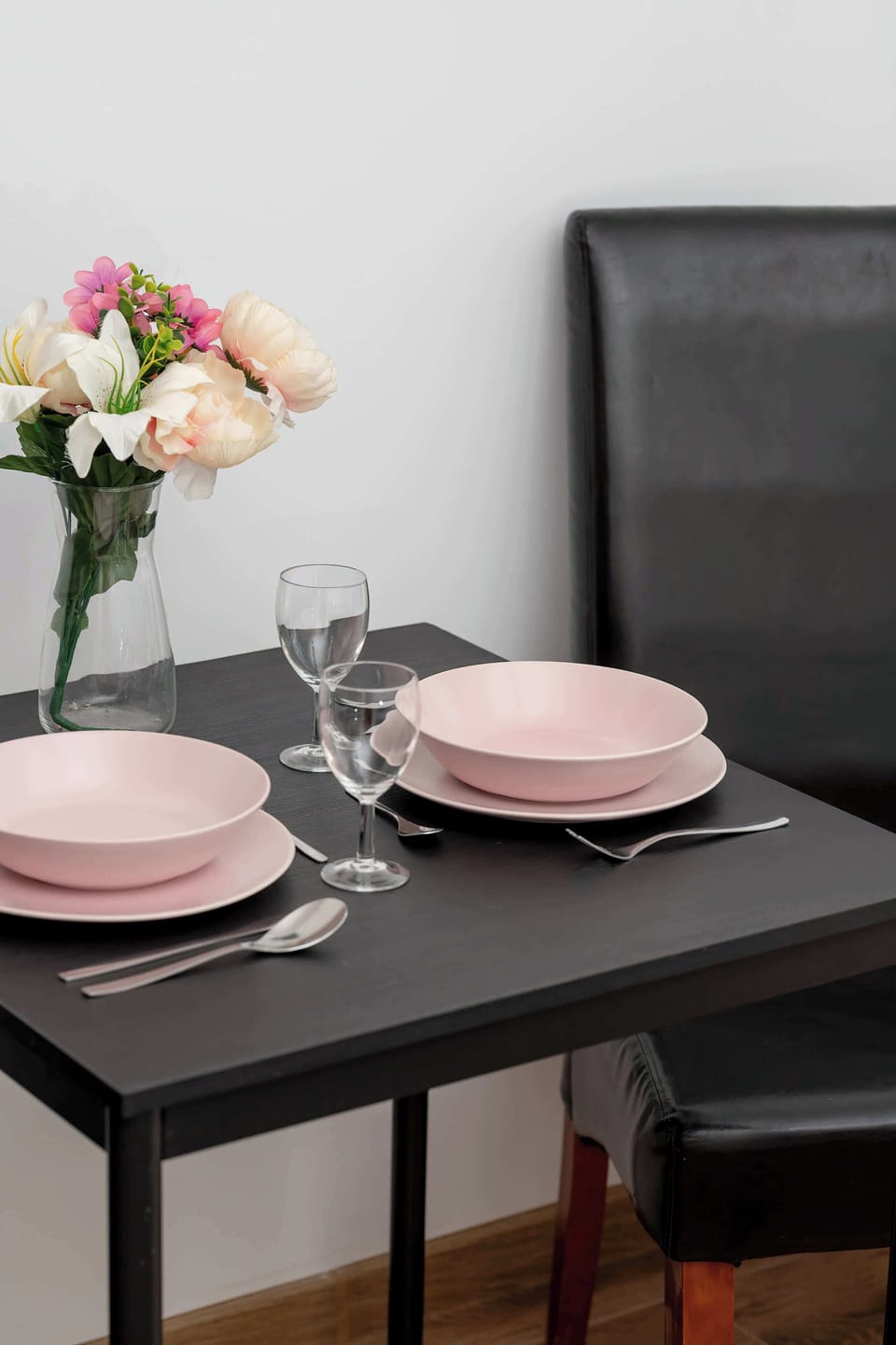 A close-up of a table setting with plates, cutlery, and decorative items, suggesting a ready-to-eat meal.