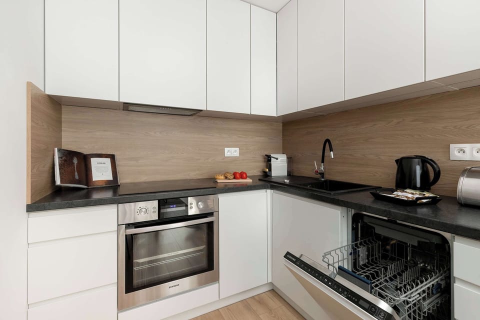 A similar L-shaped kitchen layout from a slightly different angle, highlighting the countertop space and neatly arranged appliances.