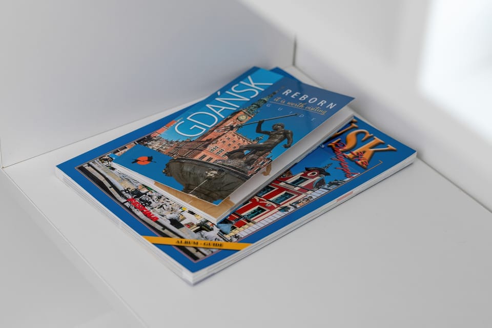 A small stack of magazines placed on a white table, neatly arranged for guests.