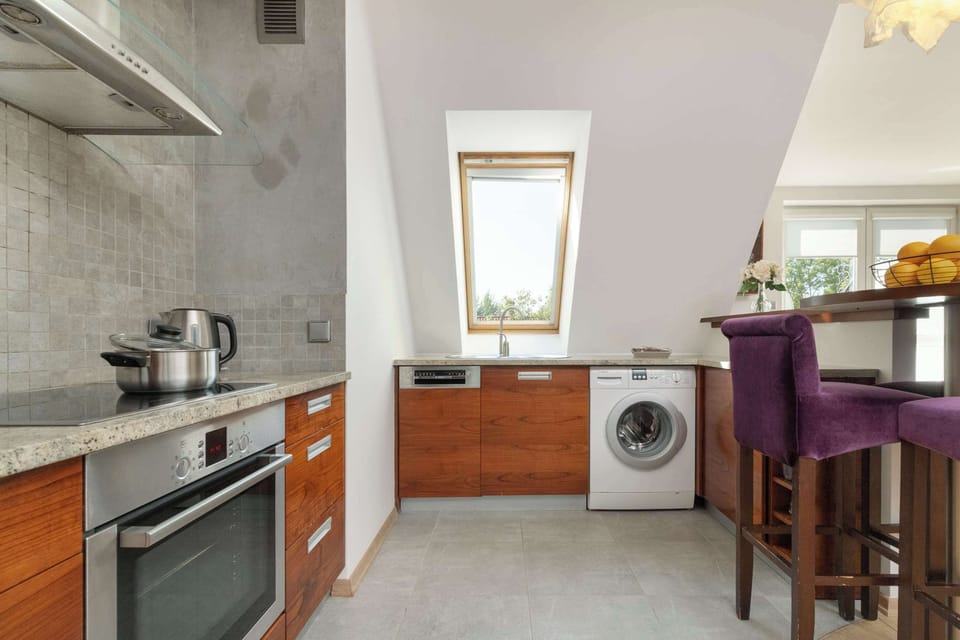 Aneks kuchenny z meblami na wymiar oraz nowoczesnymi sprzętami AGD.