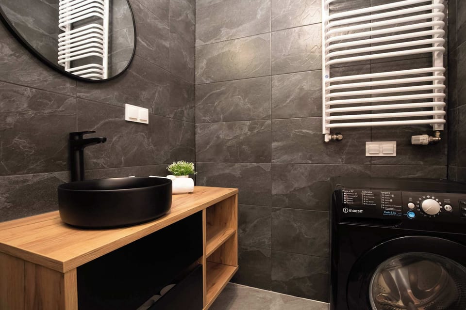 The bathroom's contemporary design includes fresh towels and a hairdryer.