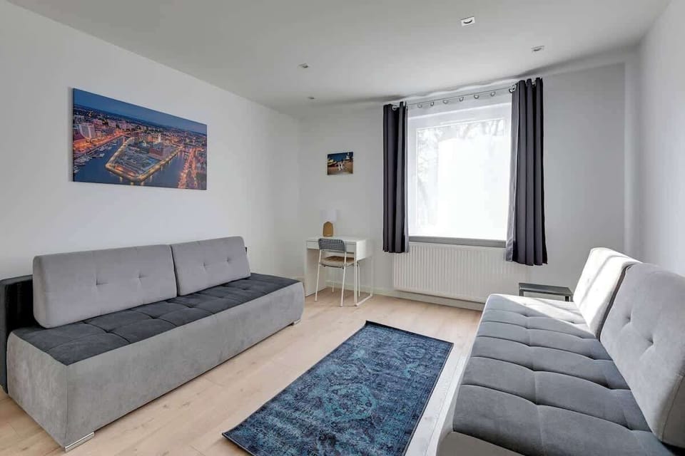  A cozy bedroom with a nautical style, including white brick walls, comfortable sofas, and decorative pillows with seaside motifs. It's the perfect space to relax after a busy day.