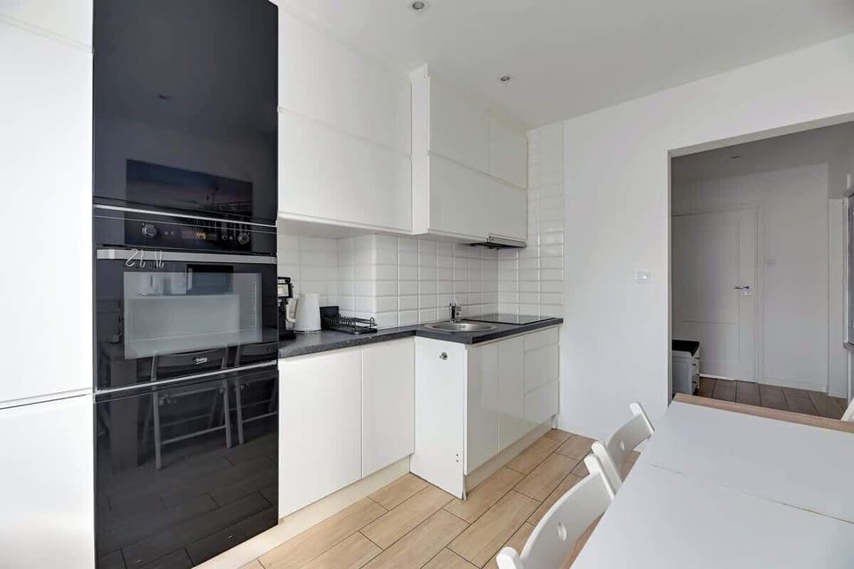 It features modern equipment such as an oven, induction cooktop, microwave, and coffee maker, perfect for coffee lovers and aromatic mornings.