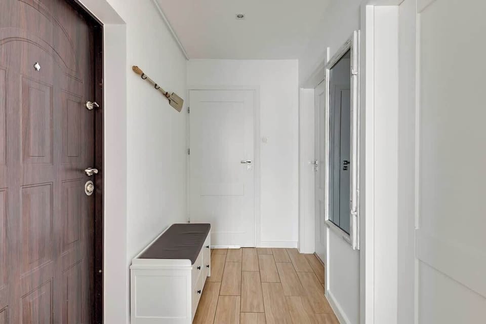 he hallway in the Siennicka apartment is designed to be both functional and stylish. It features bright, neutral-colored walls that enhance the sense of space and light.