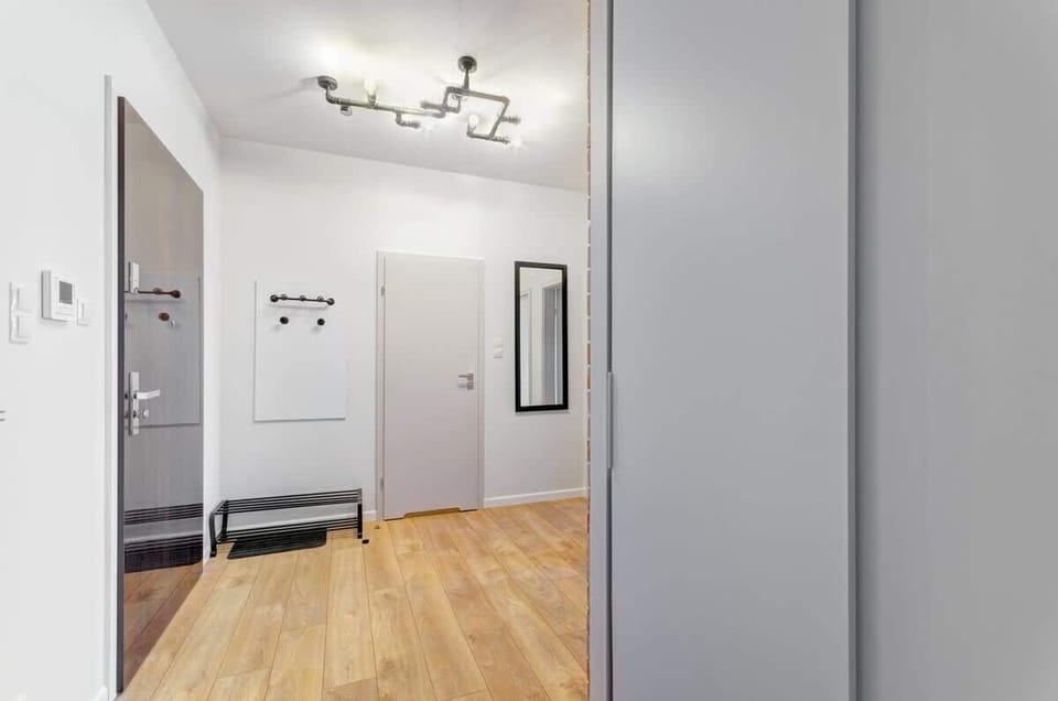 The apartment's elegant corridor welcomes guests with a cozy atmosphere. Light-colored walls and stylish lighting create a pleasant mood right from the entrance.