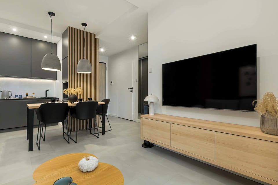 Harmonious combination of living room with smart TV and matching kitchenette.