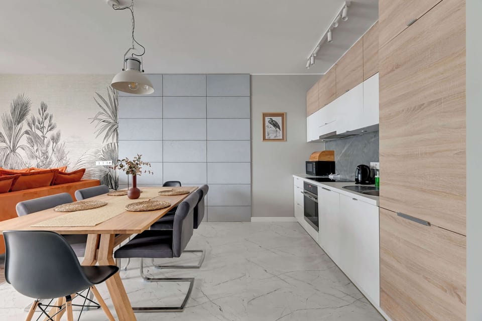 A bright dining space with a table, chairs, and pendant lighting, blending seamlessly with the kitchen.
