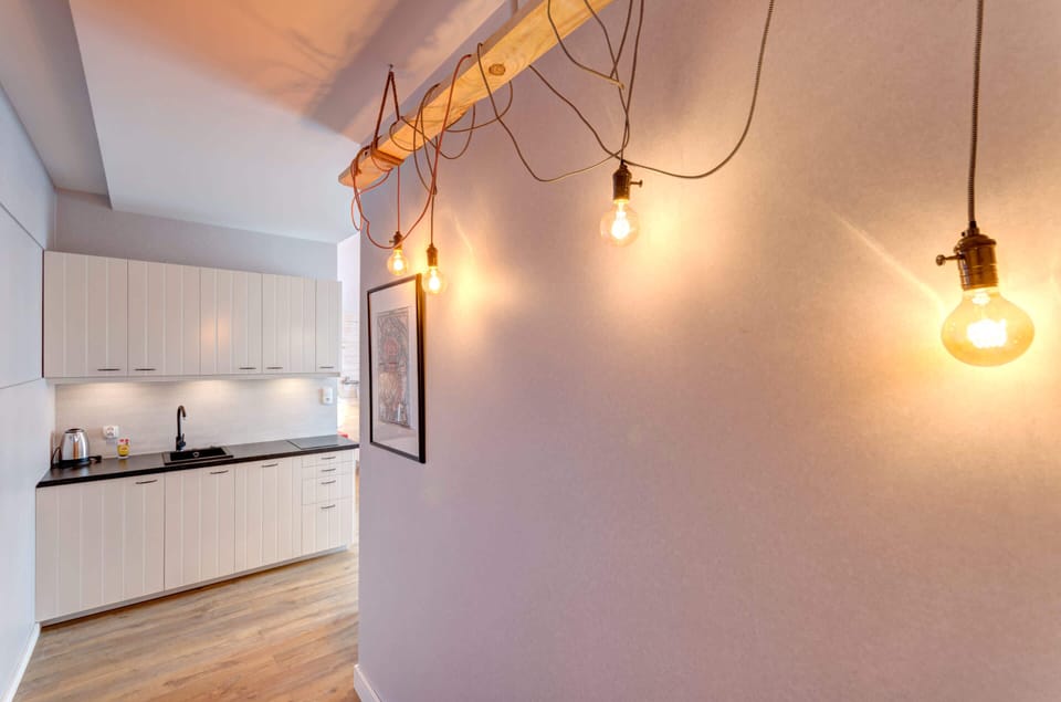 A closer view of the studio, highlighting the bed, pendant lighting, and charming design details.