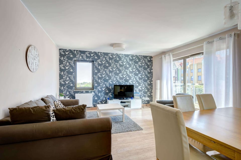 Spacious living room with a sofa bed, TV and dining area.