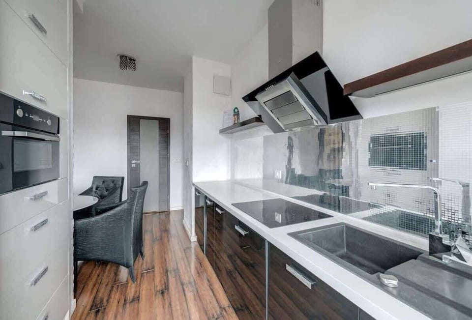 The simple yet elegant design of the furniture, combined with practical cabinets, guarantees organization and spaciousness. The bright lighting complements the kitchen, making it a pleasant space to cook and spend time in.