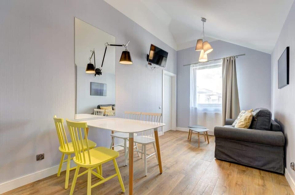 The living room also features a table and chairs, which is an interesting color accent. The mirror above the table enlarges the interior and adds style. 