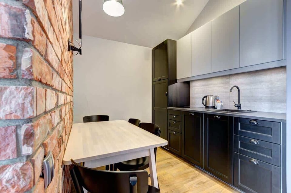 A functional kitchen with a modern design serves as the perfect space for meal preparation. Dark cabinet fronts contrast beautifully with a light countertop, creating an elegant interior.