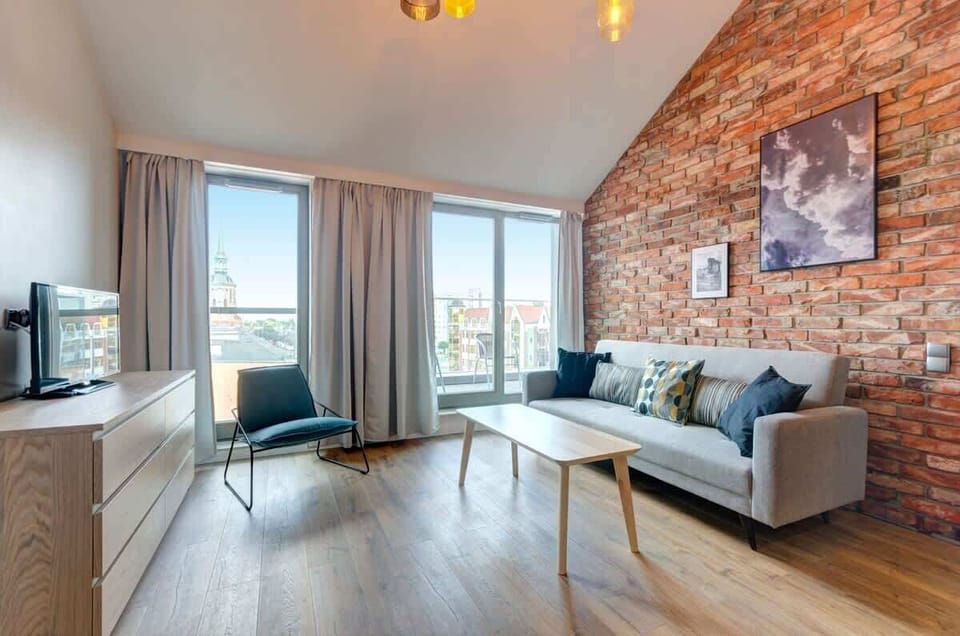 The living room of the apartment is a space full of elegance and comfort, designed for relaxation. A comfortable upholstered sofa in a neutral tone, paired with subtle decorations, creates a cozy atmosphere.