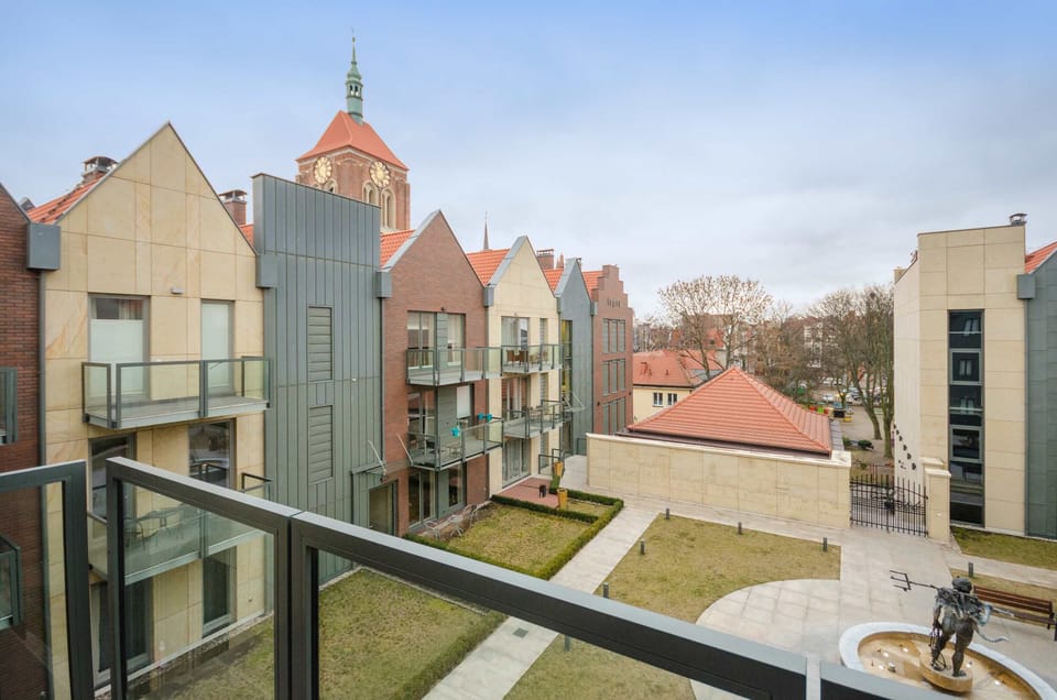 A view of the surrounding area, showcasing modern architecture and an open courtyard with nearby buildings.