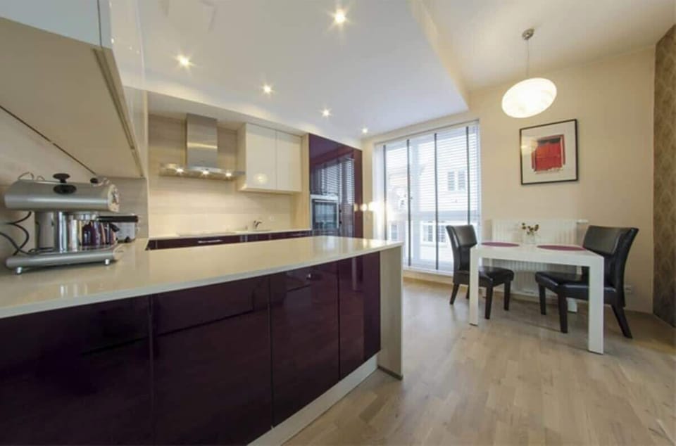 A stylish and modern kitchen that impresses not only with its appearance but also with its functionality. Shiny cabinet fronts in a deep burgundy shade combined with light countertops create a harmonious composition that draws attention.