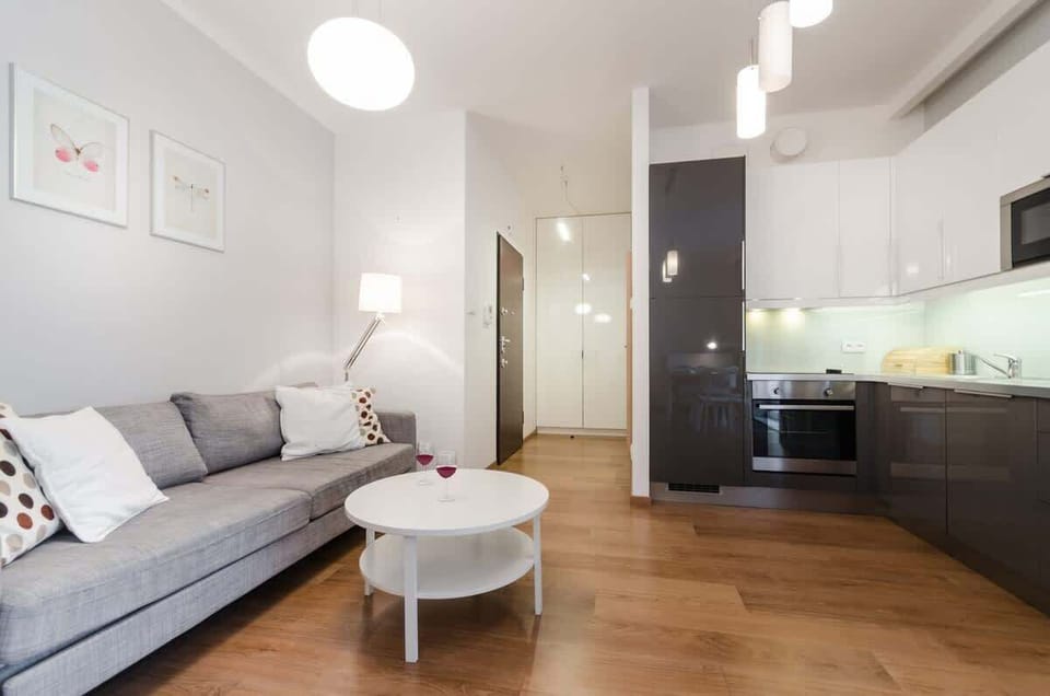 A spacious living room with a large gray sofa and a designer coffee table invites you to relax in a modern, stylish atmosphere. Subtle decorations, such as minimalist artwork on the walls and light wooden accents, bring harmony.