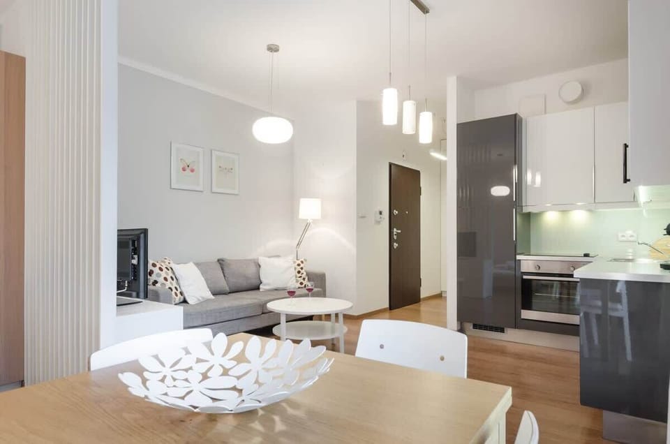 Subtle decorations, such as minimalist artwork on the walls and light wooden accents, bring harmony. Large windows allow plenty of light to fill the room, and a flat-screen TV provides additional entertainment.