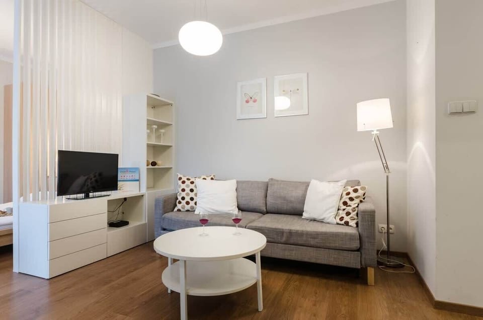 A spacious living room with a large gray sofa and a designer coffee table invites you to relax in a modern, stylish atmosphere.