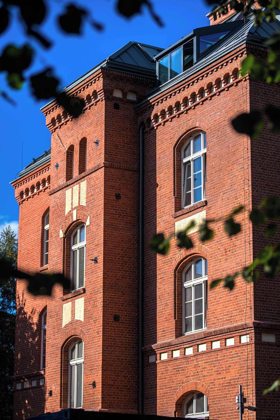 A charming brick building surrounded by greenery, highlighting the historic yet modern character of the area.