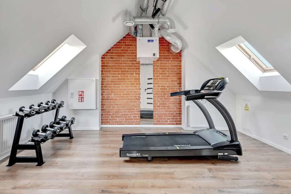 Striking contrast between the exposed brick wall and sleek, high-end fitness equipment, creating a clean, functional, and inviting workout environment.