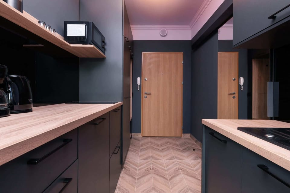 A view of the kitchen from a different angle, emphasizing wood details and a stylish backsplash.
