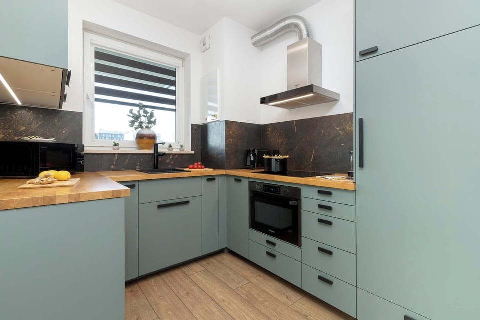 A wider view of the kitchen, highlighting its layout and a mix of wood and metal finishes.