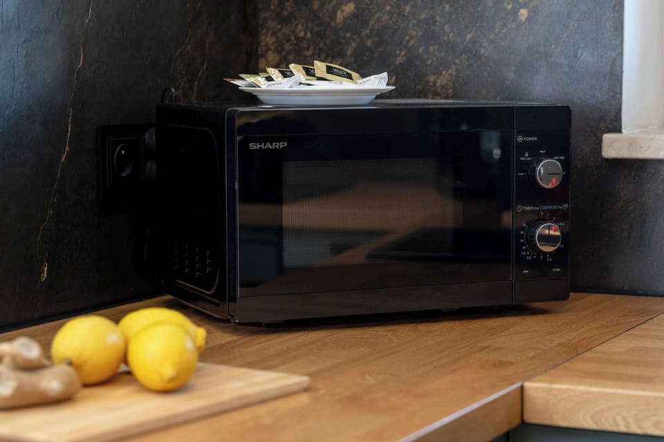 A closer look at the kitchen counter with a microwave, lemons, and clean, modern finishes.