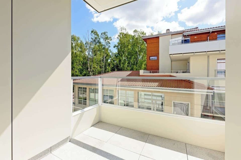  A picturesque view of the building's balcony area with a sitting space designed for relaxation.