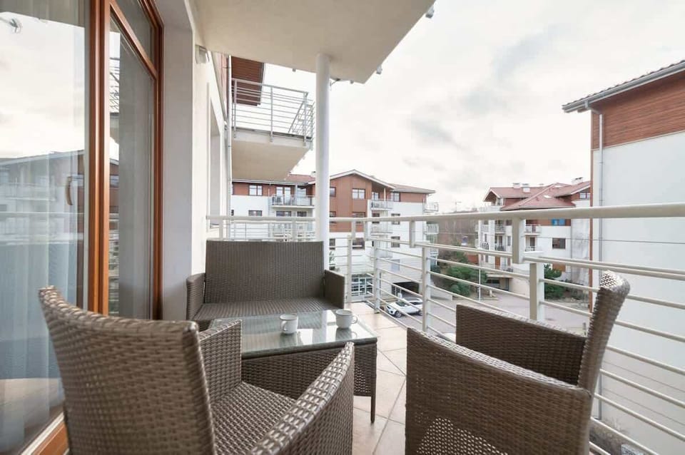 A cozy outdoor seating area featuring wicker chairs and a view of the peaceful residential surroundings.