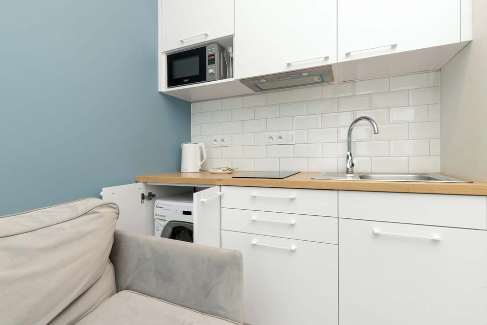 Kitchenette with wooden countertop and built-in microwave.