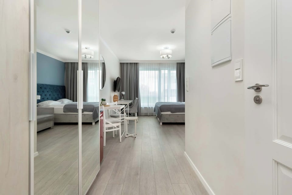Cozy living and dining area with mirrored wardrobe and neutral tones.