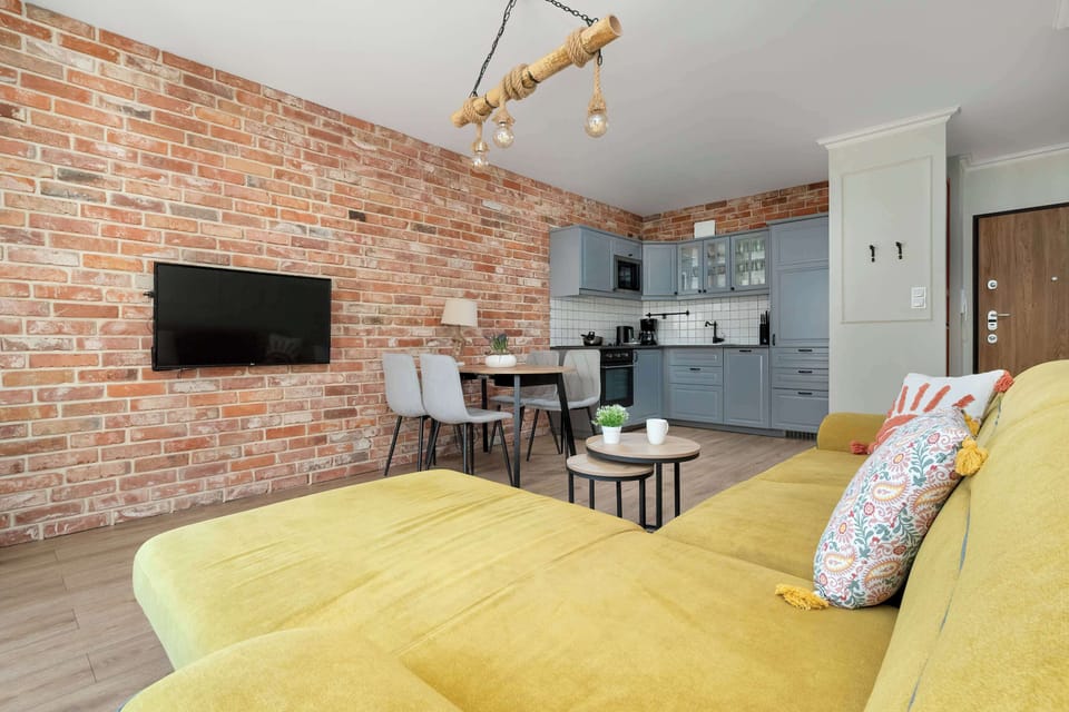 Living room with a fold-out sofa bed, Smart TV and kitchenette.