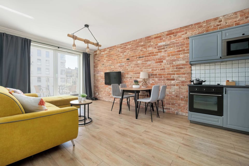 Spacious living room with a fold-out sofa bed, TV and kitchenette with dining area.